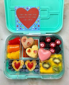 a bento box filled with fruit and veggies in the shape of hearts