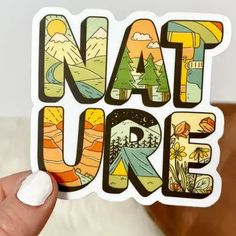 someone holding up a sticker that says nature