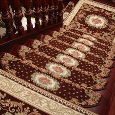 the rugs are lined up on the floor in front of the stair case and railing