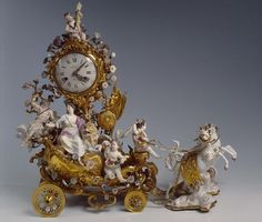 an ornate clock with figurines riding on a horse drawn carriage and other items