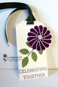 a tag that says celebrating together with a purple flower on the front and green leaves on the back