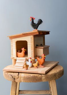 a wooden table topped with chickens and a chicken house on top of it's legs