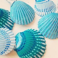 four blue seashells sitting on top of a white table