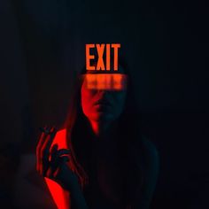 a woman with an exit light on her head and the word exit projected over her face