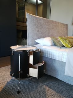 a bed with a drum set sitting on top of it next to a night stand