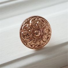 a close up of a ring on a window sill with white wood in the background