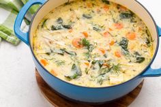 a blue pot filled with soup on top of a wooden board