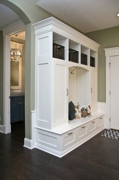 a large white cabinet in the middle of a room with built - in bookshelves