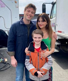 a man standing next to a woman and a boy in front of a food truck