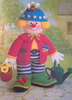 a knitted doll is holding a watering can and a flower pot in its hand