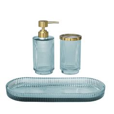 a glass bathroom set with soap dispenser and toothbrush holder