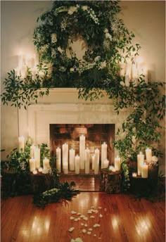 the fireplace is decorated with candles and greenery