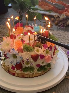 a birthday cake with flowers and candles on it