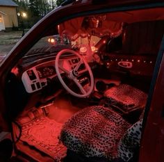 the interior of a car with red lights and leopard print pillows on the floor,