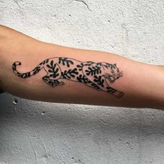 a black and white tiger tattoo on the right arm with leaves in it's tail