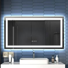 a bathroom vanity with a lighted mirror above it