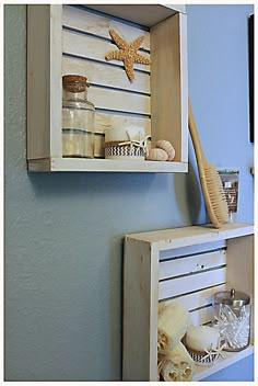 two wooden boxes with shells and other items in them on the wall next to each other