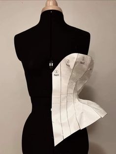 a black mannequin with white paper on it's back and side panels