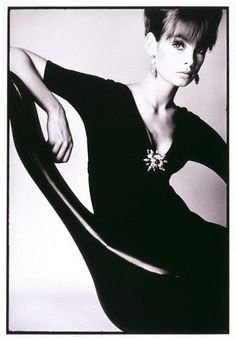 a black and white photo of a woman in a chair with her arm on the back