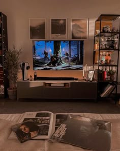 an entertainment center in a living room with movies on the wall and posters above it