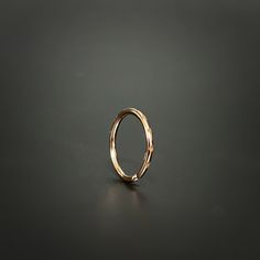 a gold ring on a black surface with no other object in the photo to be seen