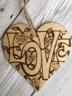 a wooden heart shaped ornament with the word love on it