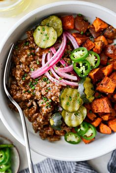 a white bowl filled with meat and veggies