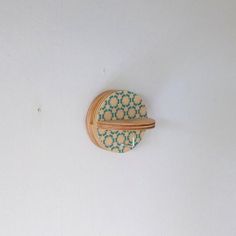 a wooden object with blue and white designs on it's side hanging from the wall