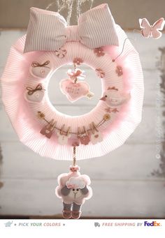 a pink heart shaped wreath hanging from the ceiling next to a teddy bear and other decorations