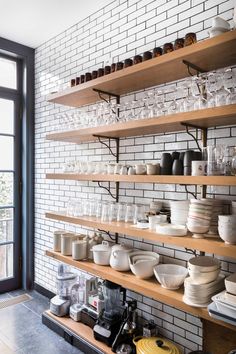 the shelves are filled with dishes and glasses on them, along with other kitchen items