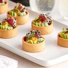 small appetizers are arranged on a white tray