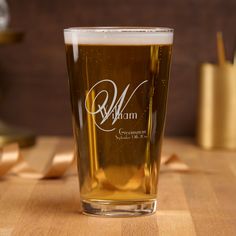 a beer glass sitting on top of a wooden table