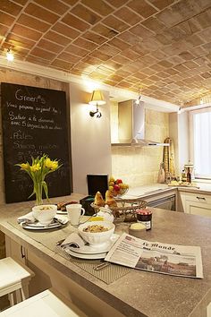 a kitchen filled with lots of counter top space next to a chalkboard on the wall