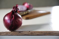 an onion sitting on top of a wooden cutting board