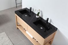 two black sinks sitting on top of a wooden cabinet