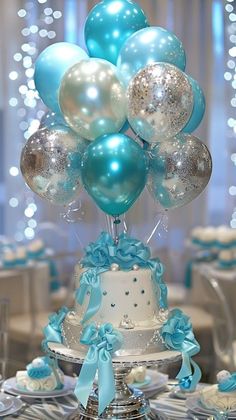 there is a cake and balloons on the table at this wedding reception in blue and silver