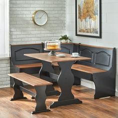 a corner table with benches and a clock on the wall behind it in a dining room