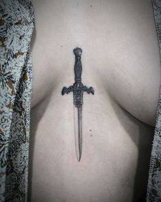 a knife tattoo on the side of a woman's breast is shown in this image