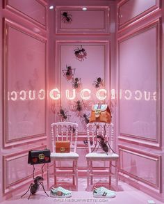 two white chairs in front of a pink wall with bugs on it and the words gucci