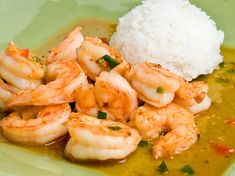 a green plate topped with shrimp and rice