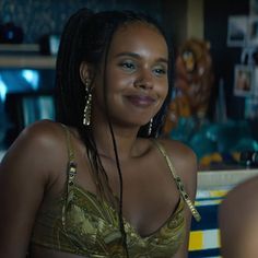 a woman with braids sitting in front of a counter top smiling at the camera