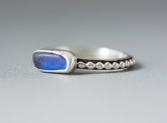 a silver ring with a blue stone in it