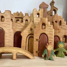 some wooden toys sitting on top of a table next to a building and a bridge