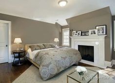 a bedroom with a bed, fireplace and pictures on the wall