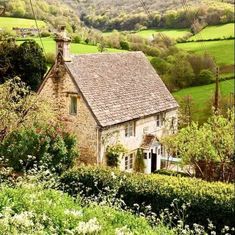 an old stone house surrounded by lush green hills