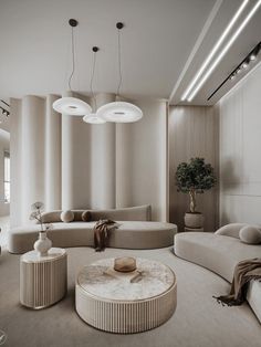 an elegant living room with round couches and lamps hanging from the ceiling above it