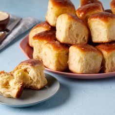 there is a plate full of rolls and a bowl with dipping sauce on the side