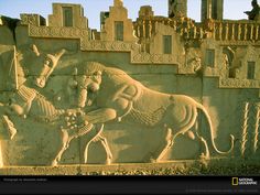 an intricately carved stone wall depicting two men and a horse in front of a castle