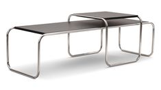 two tables with metal legs and black tops, one on each side is an open end table