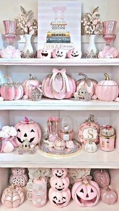 a shelf filled with lots of pink pumpkins and other decorative items on top of it